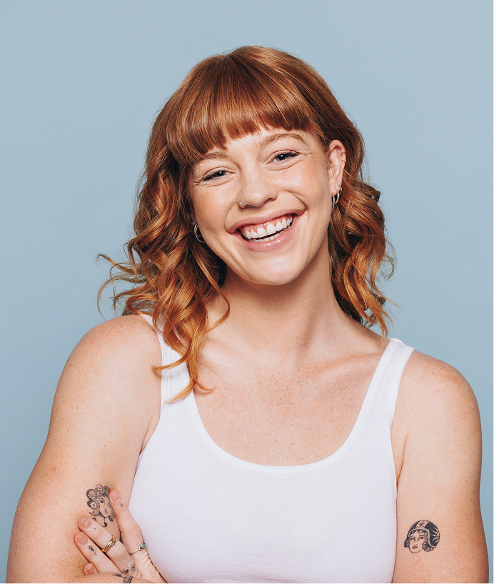 redheaded smiling girl with a tattoo