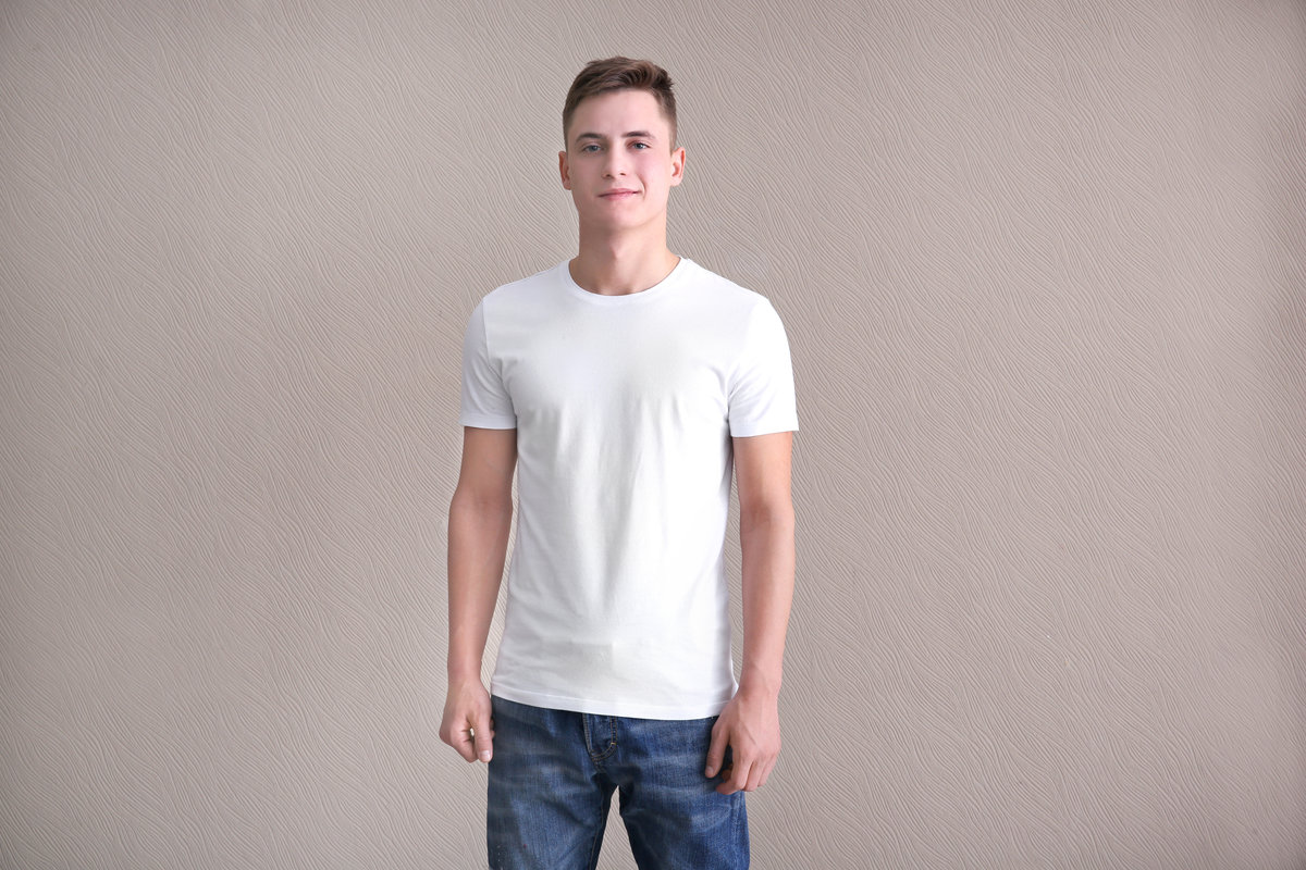 Young man in color t-shirt on light background. Mockup for design