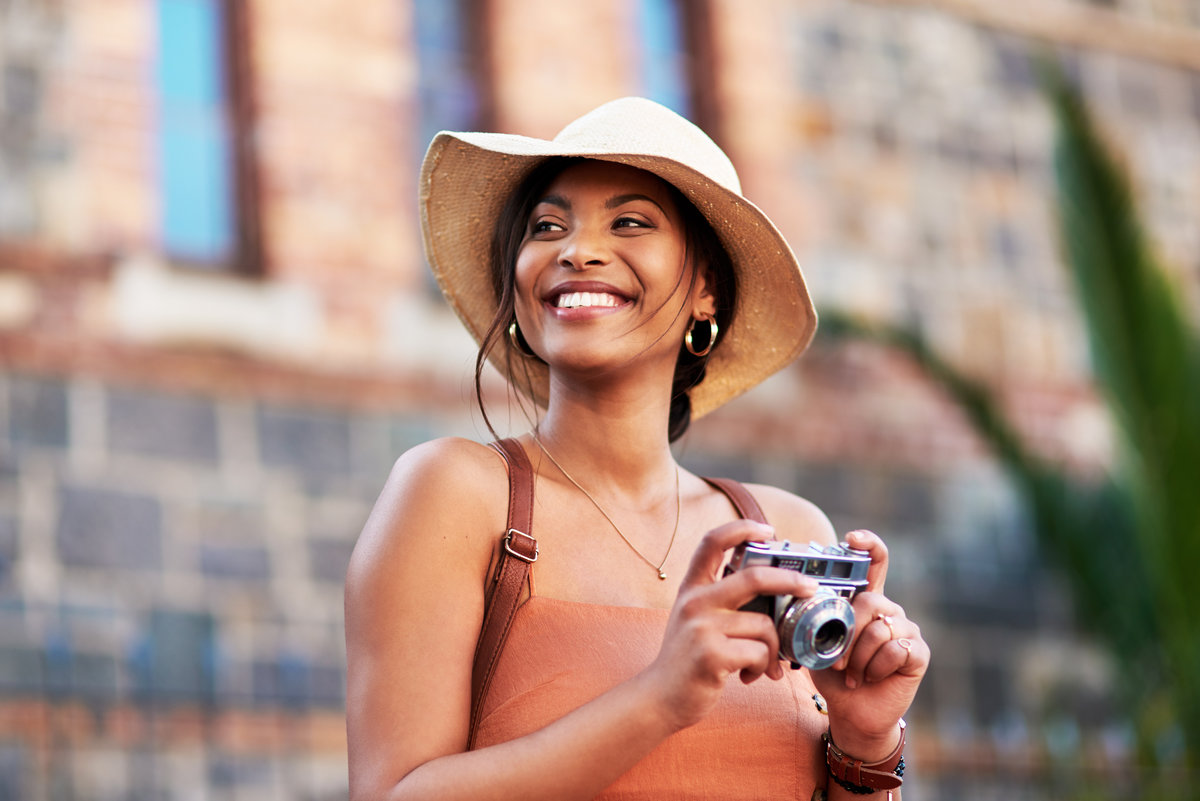 Shot of an attractive young woman taking pictures with a camera while exploring in a foreign city.