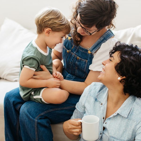 LGBT couple with son at home. Loving lesbian couple playing with their son while spending time together at home.