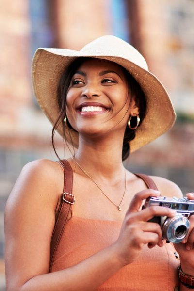 Shot of an attractive young woman taking pictures with a camera while exploring in a foreign city.