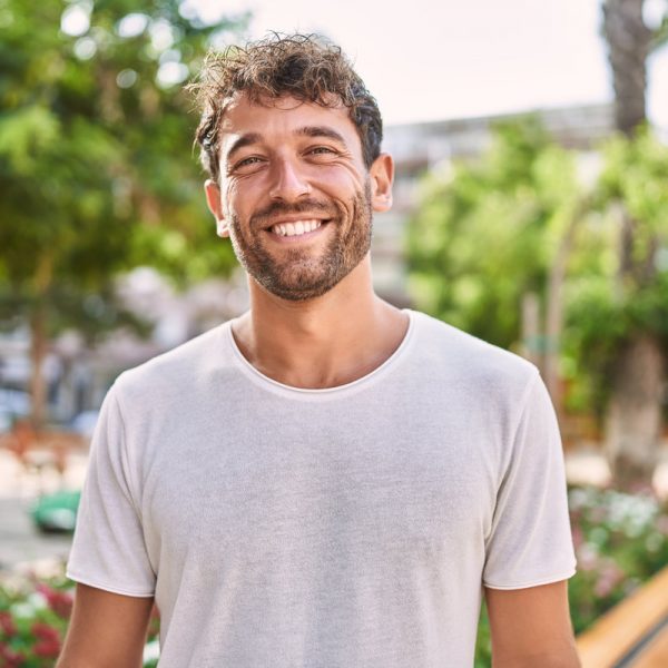 Young hispanic man smiling confident walking at park