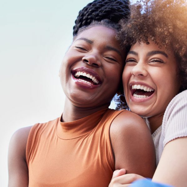 Couple of friends, black women and hug outdoor while laughing with freedom, happiness and lgbtq love. Face of happy, lesbian and african people together for space in sky or funny adventure in London.